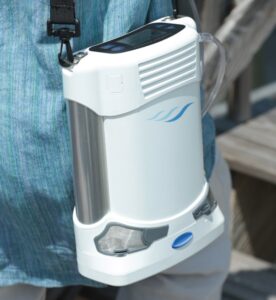 A person carrying a portable oxygen concentrator