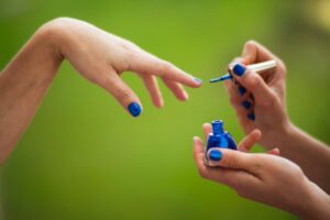 Person applying blue nail color