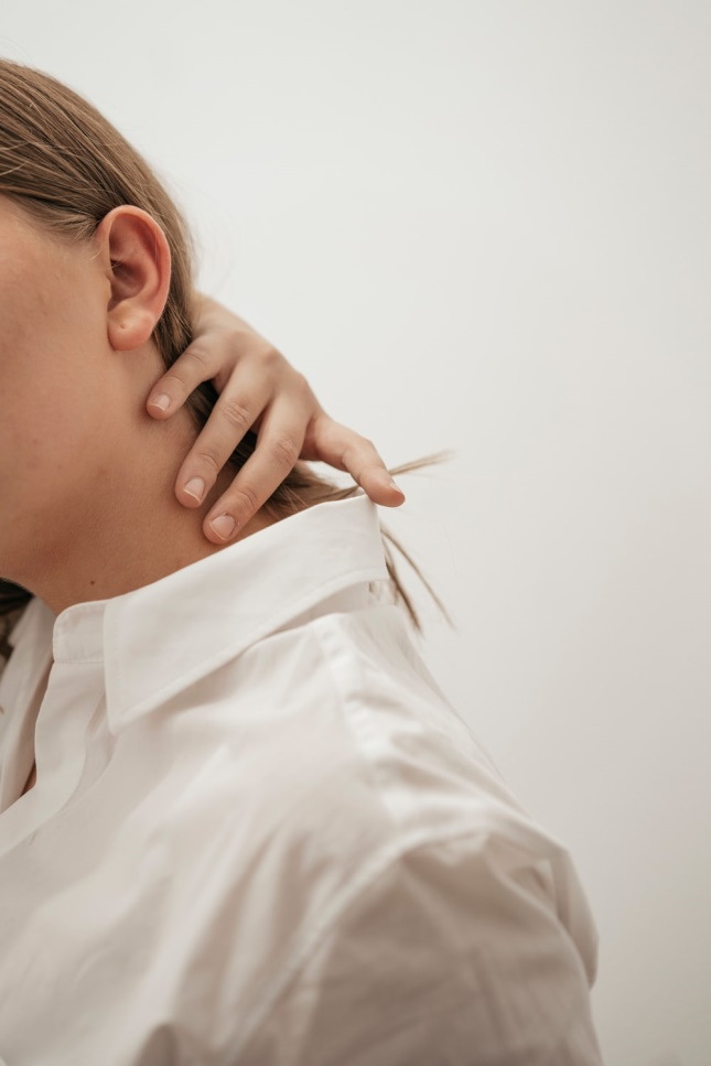 a woman holding her neck due to neck pain