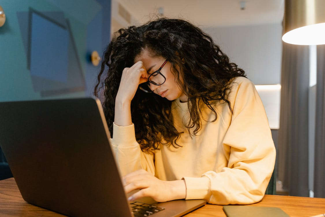 A person working on a laptop looking stressed     