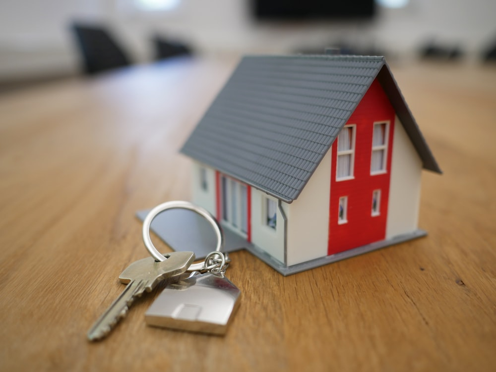 A house model alongside a bunch of keys
