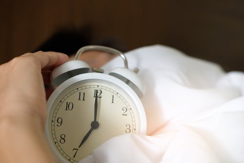 a person holding an alarm clock