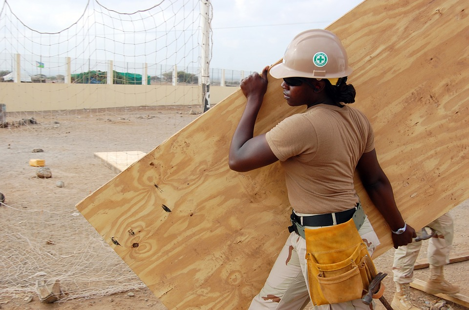woman construction worker carrying load manually