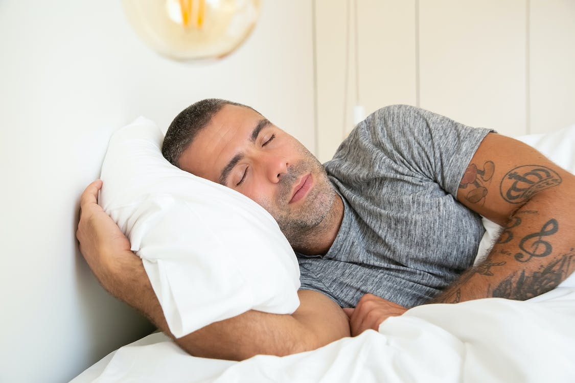  man-sleeping-with-white-pillow