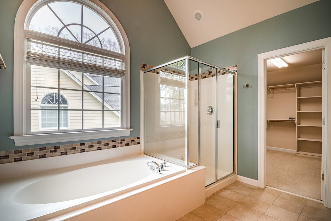 a bathroom with a tub and a glass shower enclosure 