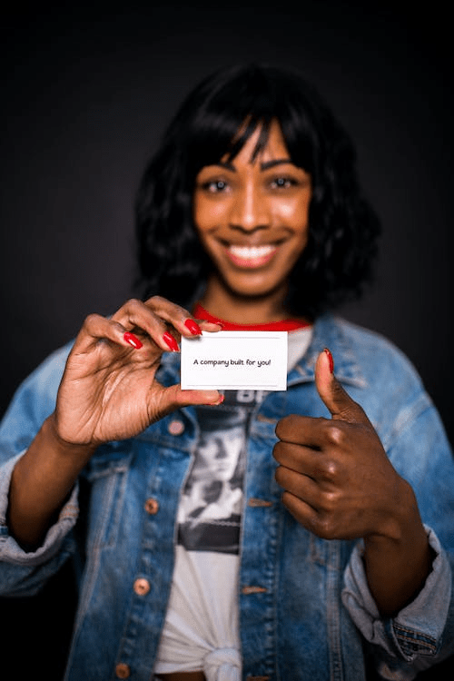 A woman holding up a business card.