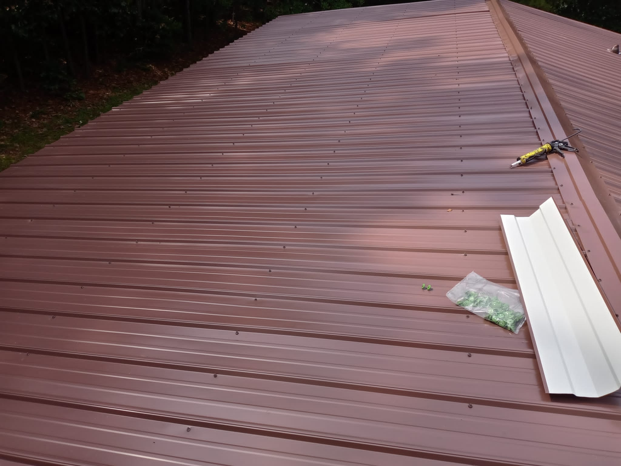 A standing seam metal roof in a maroon shade has been installed by Gator Metal Roofing.
