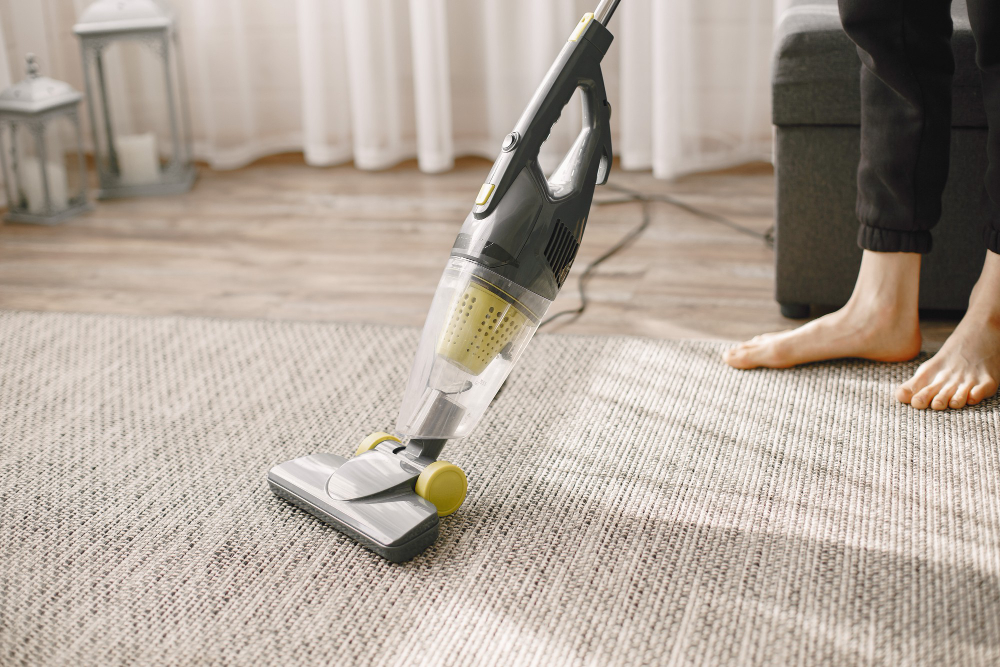 An individual using a vacuum cleaner to meticulously clean a carpet in Dublin, promoting effective carpet maintenance