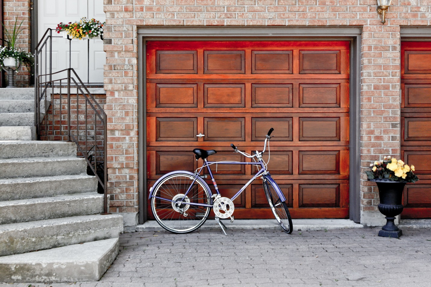 Bicycle parked in front of a wooden garage door.
