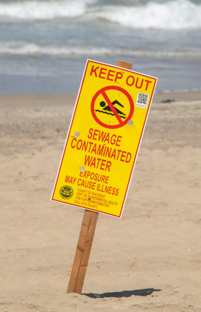 A Sign Asking People to Stay Away from a Beach Contaminated with Sewage Wastewater