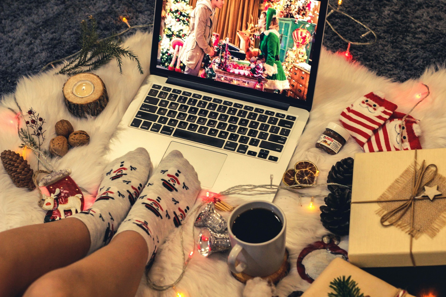 Christmas movie playing on a laptop surrounded with festive items