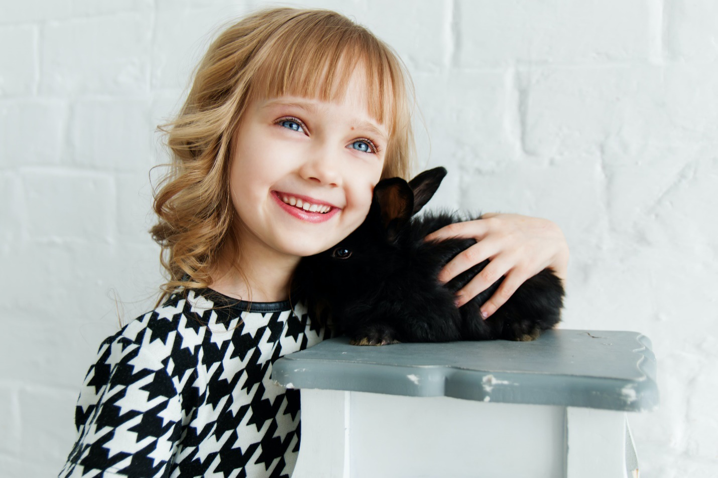  Little girl smiling and hugging a rabbit
